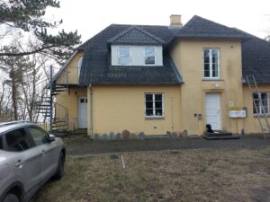 Facaden på huset på Røsnæs med eternittag, spindeltrappe og indgangsparti, før nyt stråtag