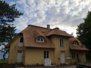 Nytækket stråtag med to nye kviste og halvmånevinduer på huset på Røsnæs