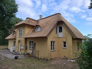 Det færdige stråtag på huset på Røsnæs fotograferet i aftenlys, juli 2024
